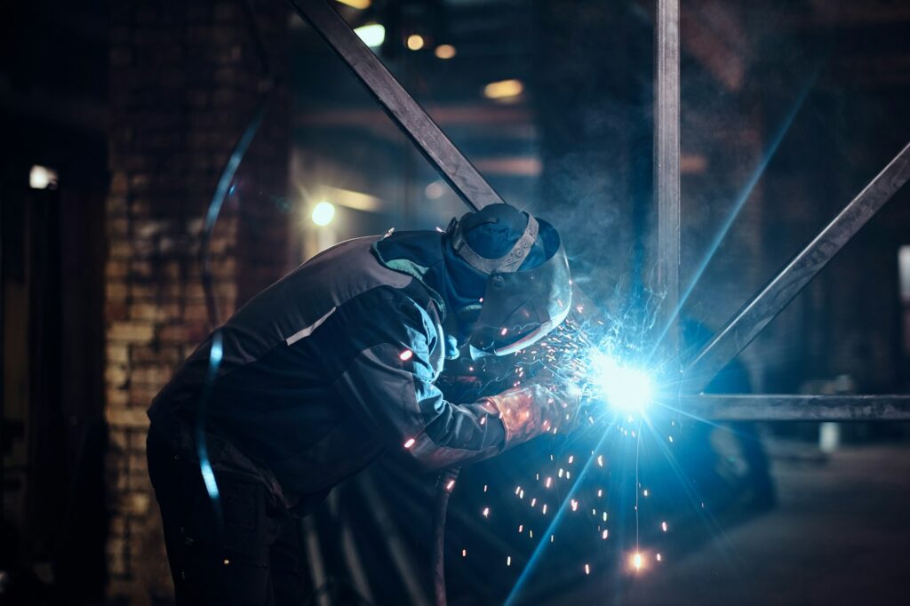 Man is working at the busy metal factory