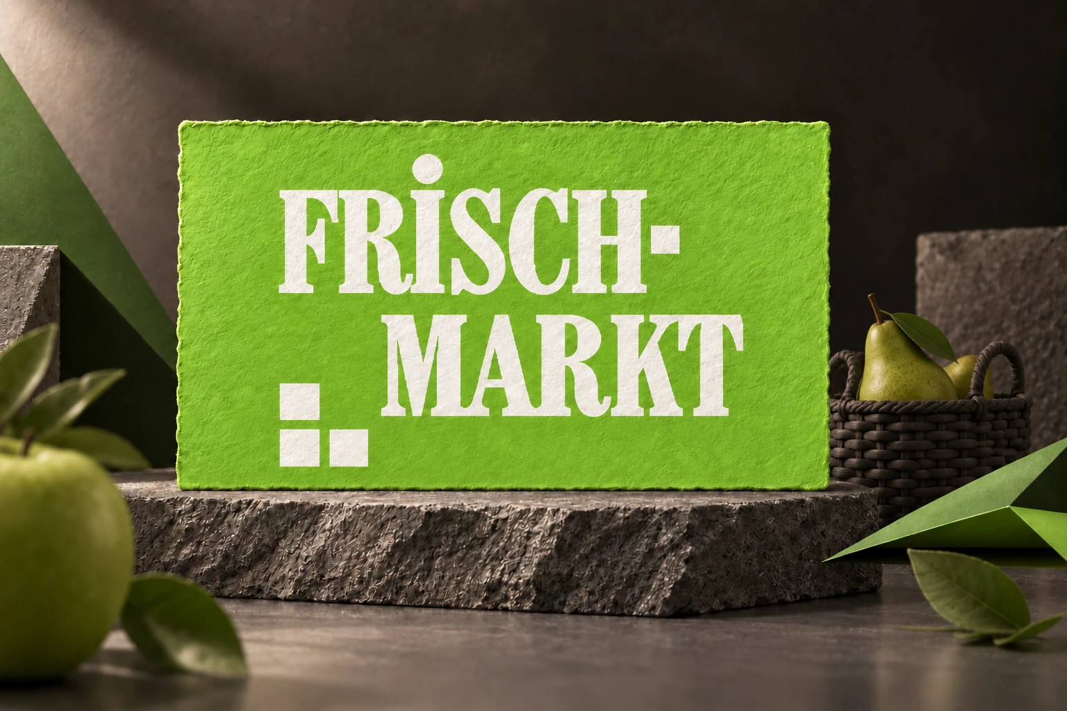 Frischmarkt-Logo auf strukturiertem grünem Papier im Atelier mit Obst und Marktkorb